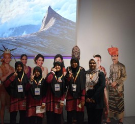 A judge interacting with students at their booth